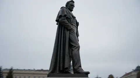 is the locked visual reference — a bronze statue of a…