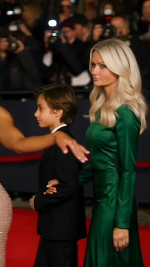Change only the hairstyle of the woman in the emerald green…
